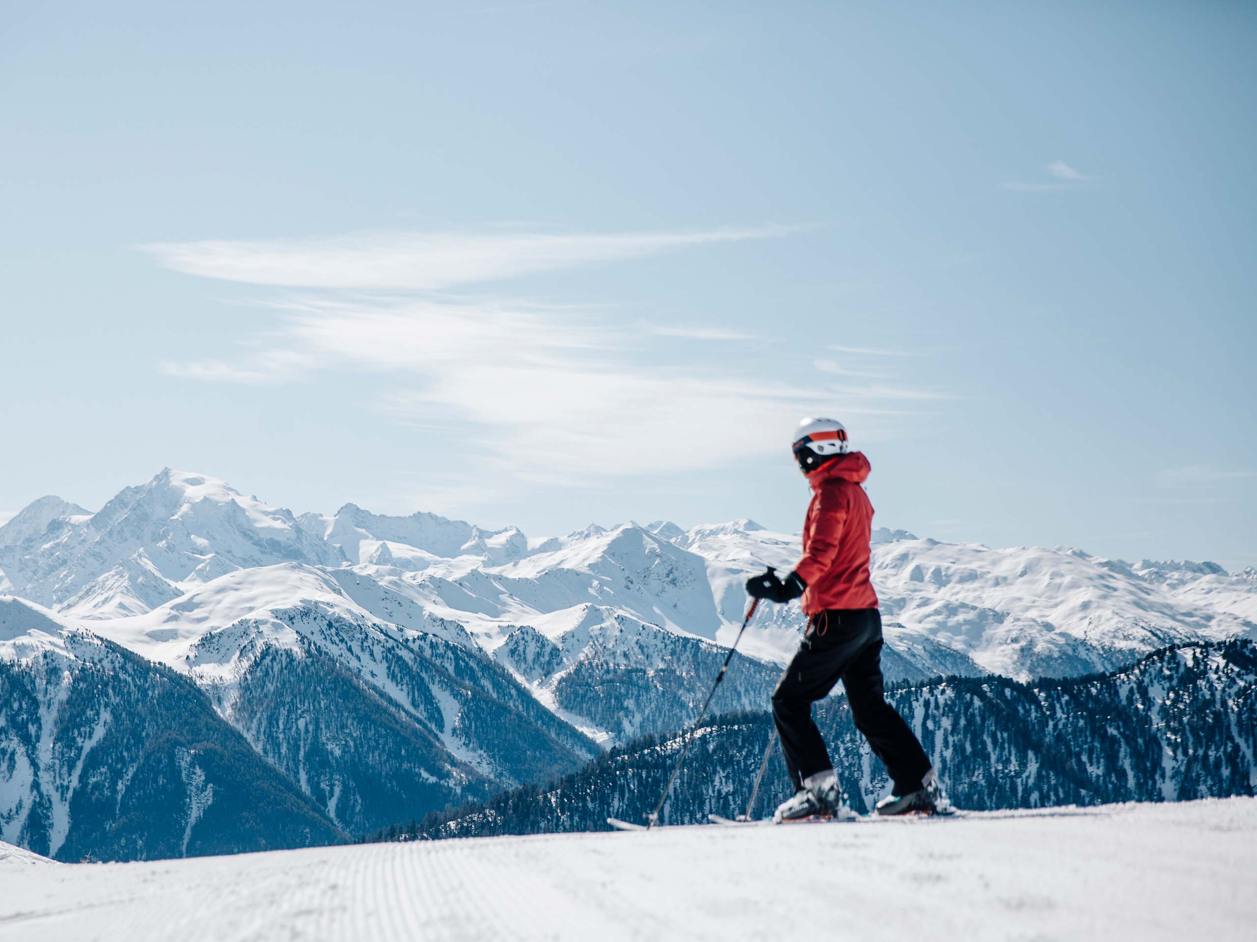 Skier on a freshly groomed slope with snowy mountain panorama in South Tyrol