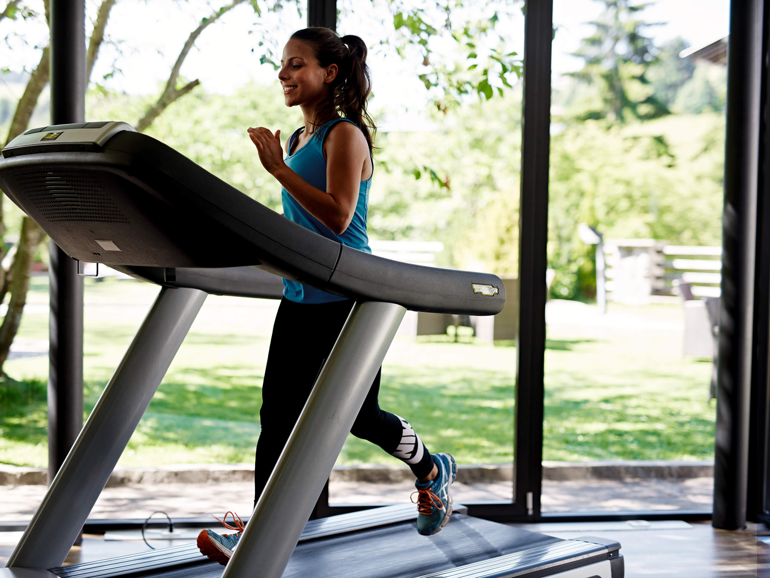 Woman jogging on treadmill indoors at Ganis Resort Dolomites Gym