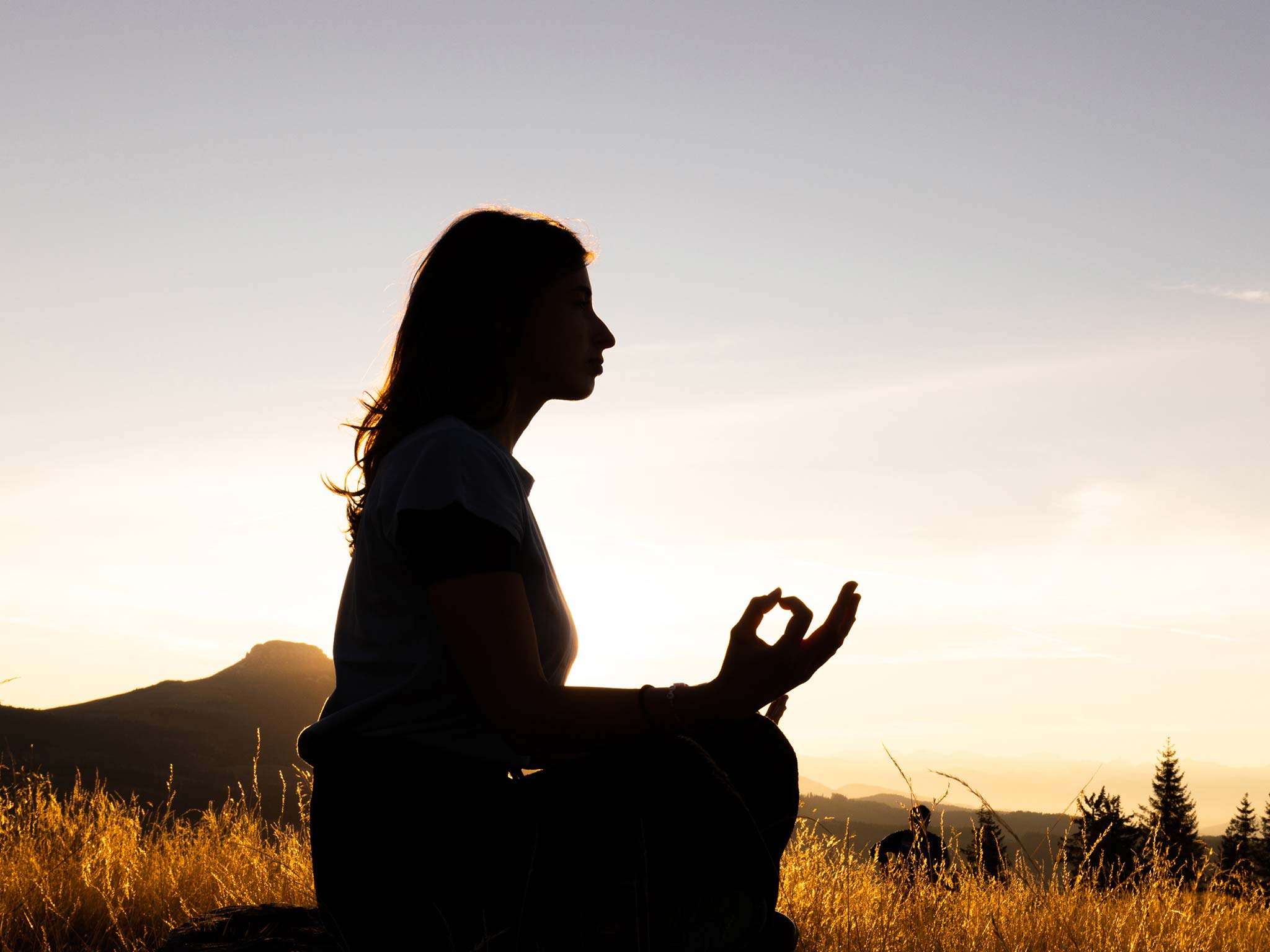 Silhouette of woman meditating at sunset at the Ganis Resort Dolomites